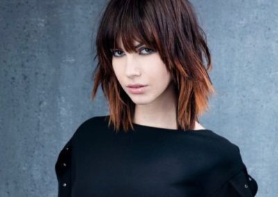 lady with long brown hair and makeup looking angry at the camera