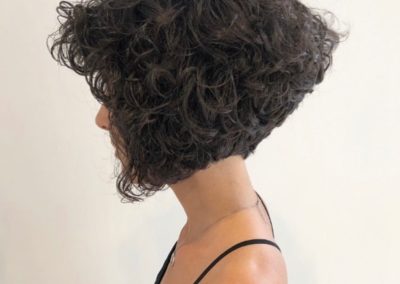 lady with long black curly hair facing sideways